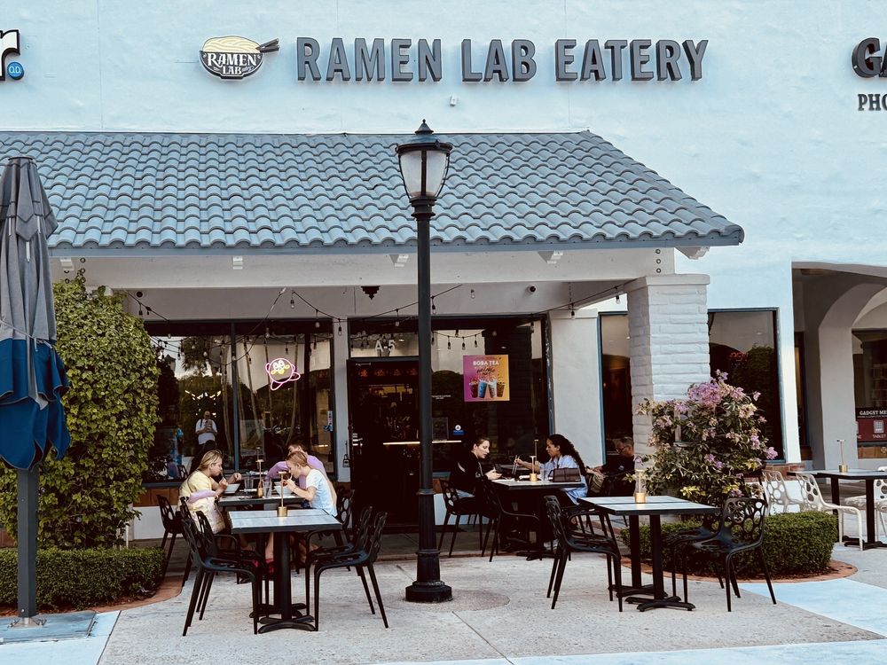 Clientes disfrutando de ramen y sushi en un restaurante local