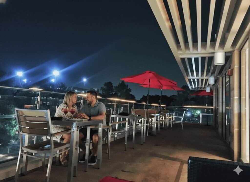 Terraza de Rose Rooftop & Restaurant en The Woodlands TX, vista 360° con luces al atardecer y ambiente romántico ideal para cenar en pareja.